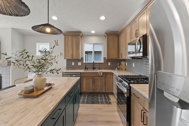 14101 E Sanson Ave, Spokane Valley, WA 99216 - kitchen featuring appliances with stainless steel finishes, a sink, light wood-type flooring, decorative backsplash, and recessed lighting