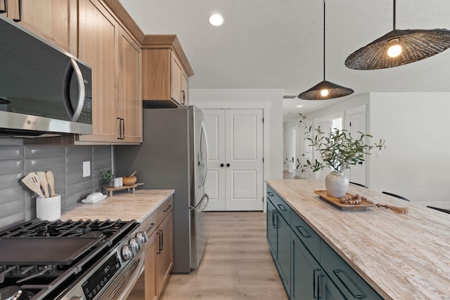 14101 E Sanson Ave, Spokane Valley, WA 99216 - kitchen featuring appliances with stainless steel finishes, light wood-style flooring, backsplash, recessed lighting, and hanging light fixtures