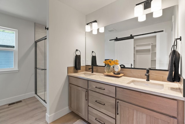 14101 E Sanson Ave, Spokane Valley, WA 99216 - full bathroom featuring double vanity, wood finished floors, baseboards, a shower stall, and decorative backsplash