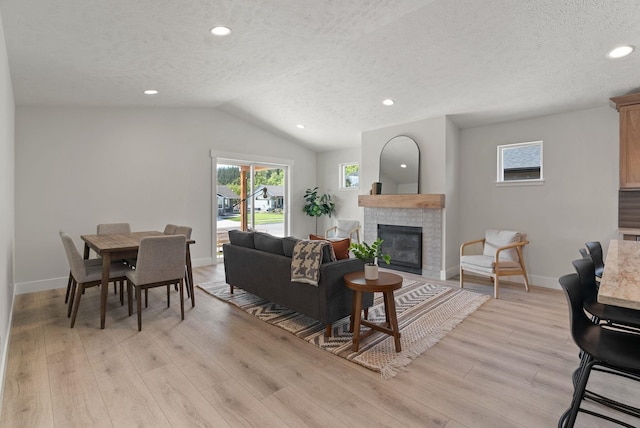 14101 E Sanson Ave, Spokane Valley, WA 99216 - living area with light wood finished floors, plenty of natural light, a textured ceiling, a fireplace, and vaulted ceiling