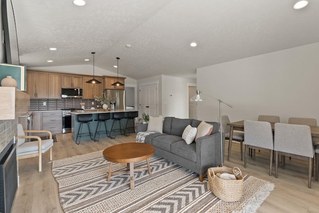 14101 E Sanson Ave, Spokane Valley, WA 99216 - living area with vaulted ceiling, light wood finished floors, a fireplace, and recessed lighting