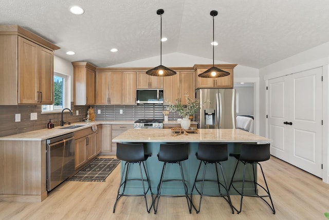 14101 E Sanson Ave, Spokane Valley, WA 99216 - kitchen featuring appliances with stainless steel finishes, a sink, lofted ceiling, light wood-type flooring, and a kitchen bar