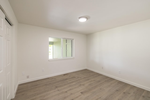 624 N Herald Rd Unit 2, Spokane Valley, WA 99206 - unfurnished bedroom with light wood-style floors, baseboards, and a closet