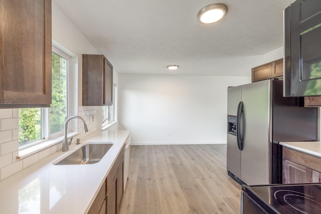 624 N Herald Rd Unit 2, Spokane Valley, WA 99206 - kitchen featuring a sink, light wood-style flooring, baseboards, backsplash, and brown cabinetry