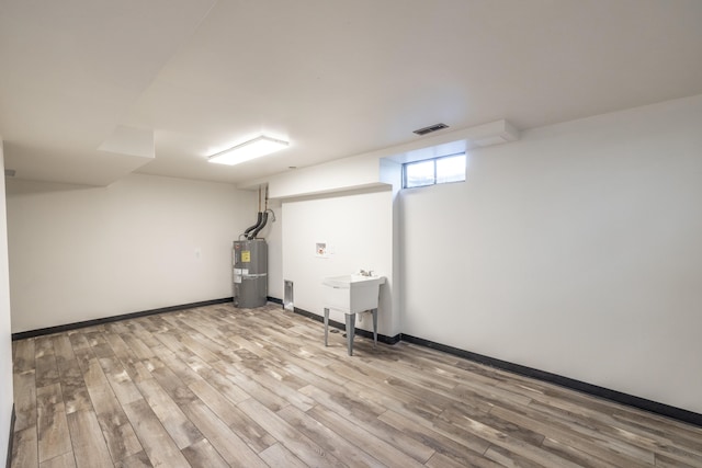 624 N Herald Rd Unit 2, Spokane Valley, WA 99206 - basement with strapped water heater, wood finished floors, baseboards, and a sink