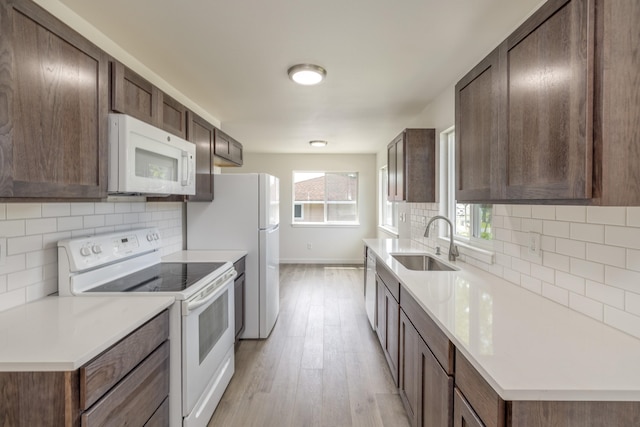 624 N Herald Rd Unit 2, Spokane Valley, WA 99206 - kitchen featuring white appliances, a sink, light wood-style floors, baseboards, and backsplash