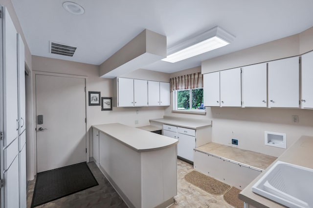 128C Buena Vista Rd, Colville, WA 99114 - kitchen featuring white cabinetry, a peninsula, a sink, and light countertops