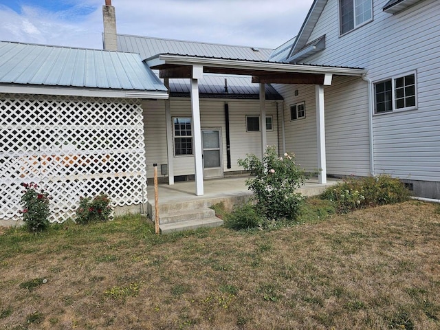 444 S Walnut St, Colville, WA 99114 - rear view of property with a lawn, metal roof, a chimney, and a porch