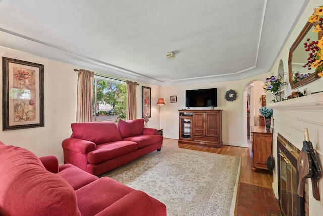 2503 W Upton Ave, Spokane, WA 99205 - living area with arched walkways, a fireplace with flush hearth, and dark wood finished floors