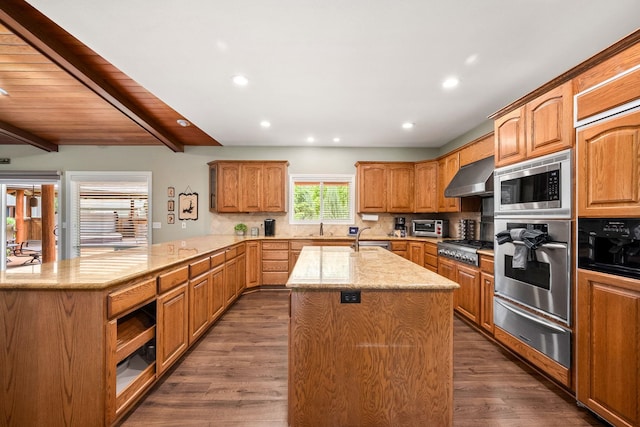 10101 N Pines Rd, Hayden, ID 83835 - kitchen featuring stainless steel appliances, a warming drawer, exhaust hood, an island with sink, and a peninsula