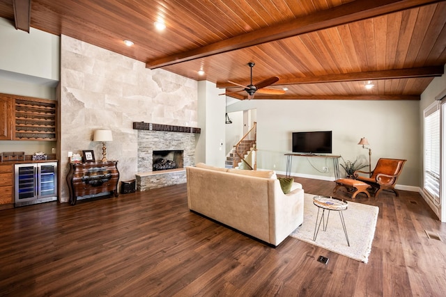 10101 N Pines Rd, Hayden, ID 83835 - living room featuring beverage cooler, wooden ceiling with exposed beams, a stone fireplace, dark wood-type flooring, and bar area