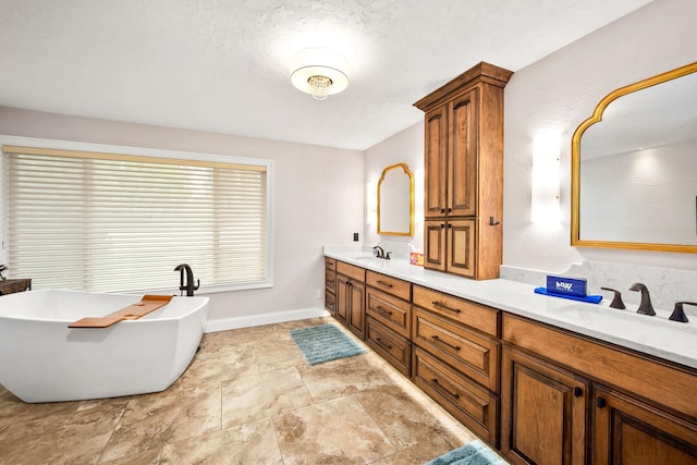 10101 N Pines Rd, Hayden, ID 83835 - bathroom featuring double vanity, a soaking tub, baseboards, and stone finish floors