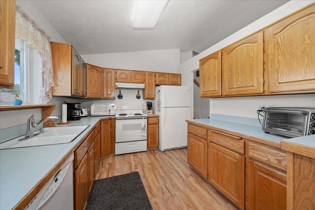 13715 E Rich Ave, Spokane Valley, WA 99216 - kitchen with white appliances, under cabinet range hood, lofted ceiling, a sink, and light wood finished floors