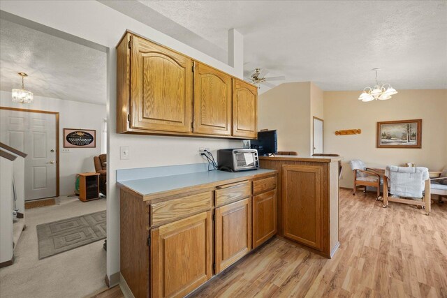 13715 E Rich Ave, Spokane Valley, WA 99216 - kitchen featuring a chandelier, a textured ceiling, light wood finished floors, a ceiling fan, and decorative light fixtures
