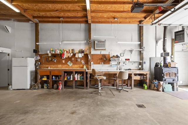 13715 E Rich Ave, Spokane Valley, WA 99216 - garage with freestanding refrigerator, a workshop area, a wall unit AC, and a garage door opener