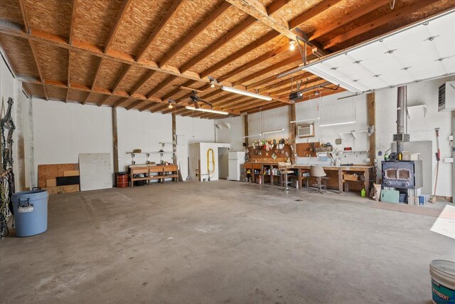 13715 E Rich Ave, Spokane Valley, WA 99216 - garage featuring a workshop area, a wall mounted AC, a garage door opener, a wood stove, and freestanding refrigerator