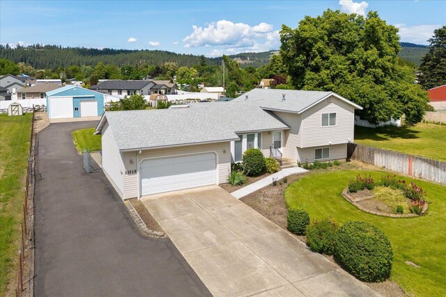 13715 E Rich Ave, Spokane Valley, WA 99216 - tri-level home featuring a garage, a shingled roof, driveway, and a view of trees