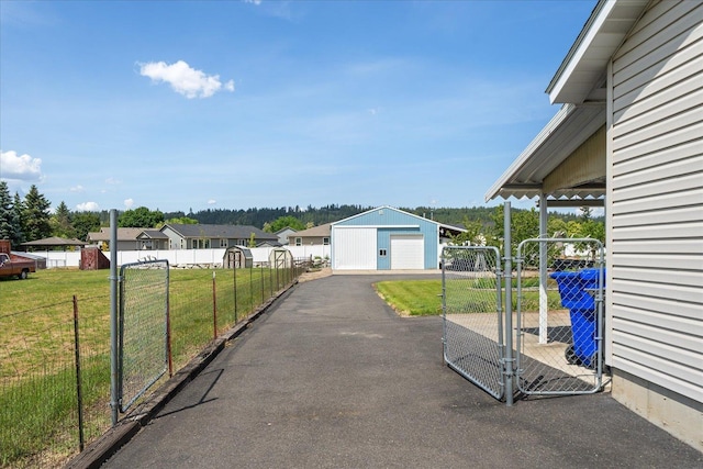 13715 E Rich Ave, Spokane Valley, WA 99216 - view of yard featuring a garage, an outdoor structure, a gate, asphalt driveway, and a residential view