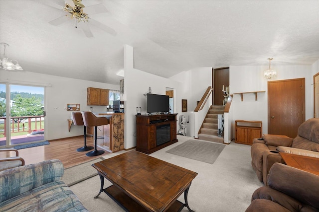 13715 E Rich Ave, Spokane Valley, WA 99216 - living room featuring a chandelier, stairs, ceiling fan, a textured ceiling, and a glass covered fireplace