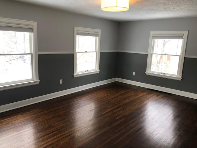 1617 S Bernard St, Spokane, WA 99203 - empty room featuring healthy amount of natural light, dark wood-style floors, baseboards, and a textured ceiling