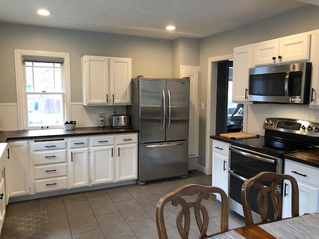 1617 S Bernard St, Spokane, WA 99203 - kitchen with appliances with stainless steel finishes, dark countertops, white cabinetry, dark tile patterned flooring, and recessed lighting