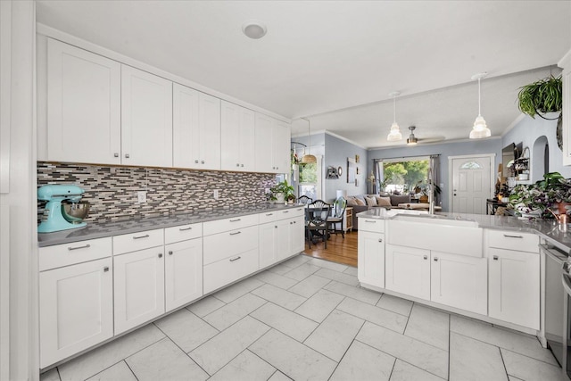 1306 W Euclid Ave, Spokane, WA 99205 - kitchen featuring a sink, open floor plan, decorative backsplash, white cabinetry, and a peninsula