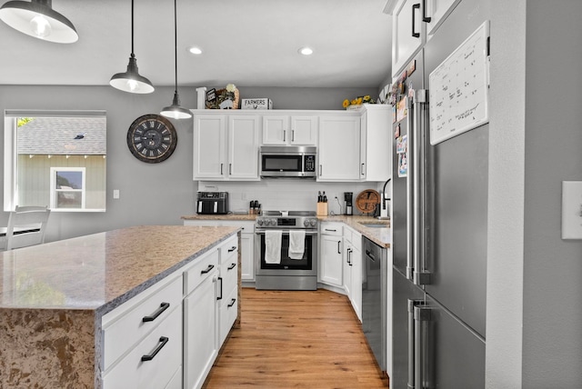 1812 E Columbia Ave, Spokane, WA 99208 - kitchen with stainless steel appliances, light wood finished floors, recessed lighting, white cabinetry, and hanging light fixtures