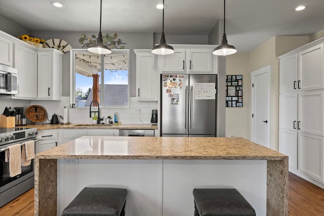 1812 E Columbia Ave, Spokane, WA 99208 - kitchen featuring appliances with stainless steel finishes, a sink, wood finished floors, white cabinets, and recessed lighting