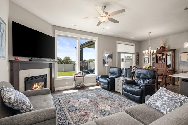 1473 W Jay Ct, Spokane, WA 99208 - living area with a tiled fireplace, wood finished floors, ceiling fan, a chandelier, and baseboards