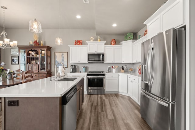 1473 W Jay Ct, Spokane, WA 99208 - kitchen featuring stainless steel appliances, a sink, light countertops, wood finished floors, and a chandelier