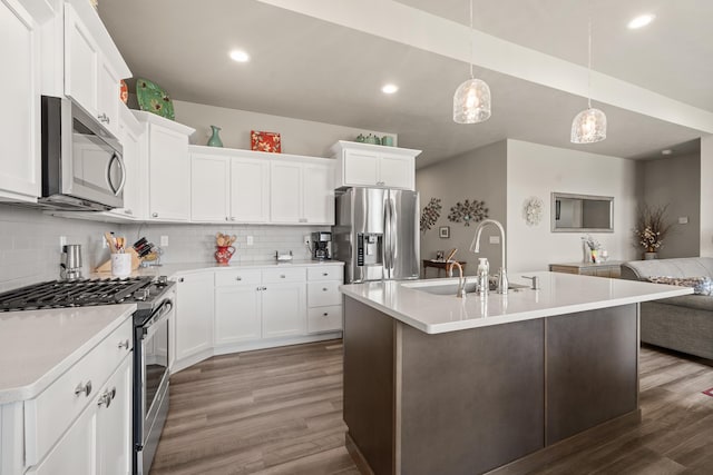 1473 W Jay Ct, Spokane, WA 99208 - kitchen with appliances with stainless steel finishes, a sink, wood finished floors, open floor plan, and backsplash