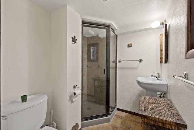 967 E 13th Ave, Spokane, WA 99202 - bathroom with toilet, a shower stall, a textured ceiling, and baseboards