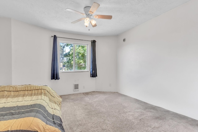 3228 E 29th Ave, Spokane, WA 99223 - unfurnished bedroom featuring carpet floors, a textured ceiling, and a ceiling fan