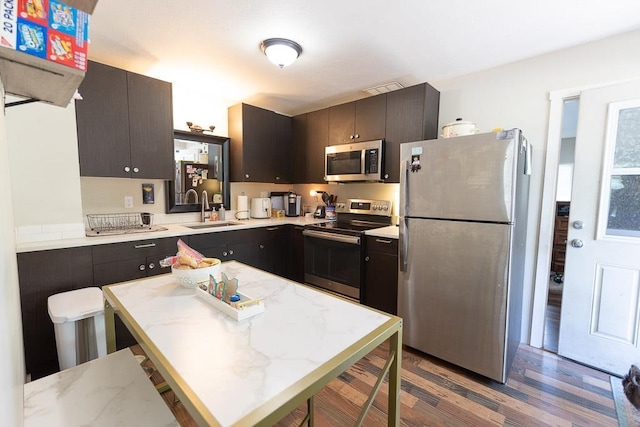 2002 15th Ave, Spokane, WA 99203 - kitchen featuring stainless steel appliances, a sink, wood finished floors, a center island, and a kitchen breakfast bar