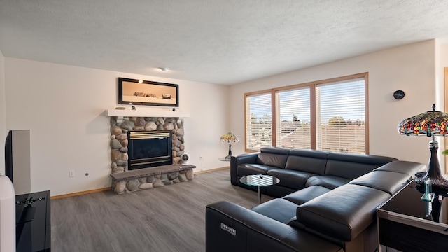 6314 W Skagit Ave, Spokane, WA 99208 - living room with baseboards, wood finished floors, a stone fireplace, and a textured ceiling