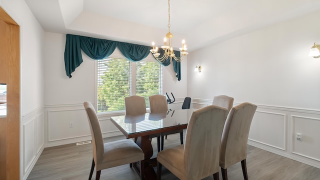 6314 W Skagit Ave, Spokane, WA 99208 - dining space with a chandelier, a decorative wall, light wood-type flooring, and a wainscoted wall