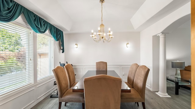 6314 W Skagit Ave, Spokane, WA 99208 - dining space with decorative columns, wood finished floors, a chandelier, a tray ceiling, and a decorative wall