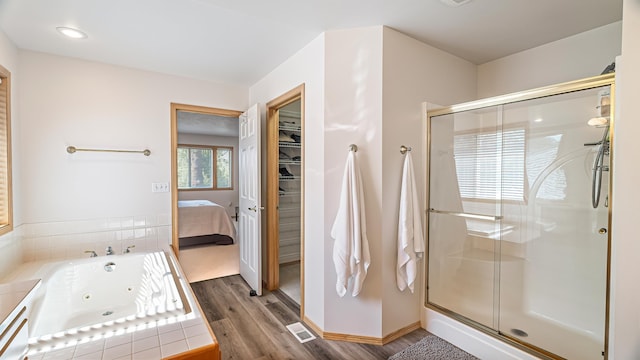 6314 W Skagit Ave, Spokane, WA 99208 - ensuite bathroom with a stall shower, a jetted tub, wood finished floors, and baseboards