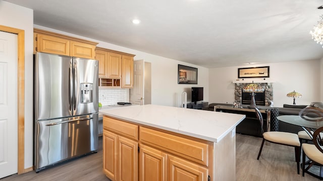 6314 W Skagit Ave, Spokane, WA 99208 - kitchen featuring stainless steel refrigerator with ice dispenser, light wood-style flooring, open floor plan, a center island, and tasteful backsplash