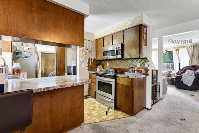 4405 E 46th Ave, Spokane, WA 99223 - kitchen with stainless steel appliances, backsplash, light colored carpet, and a sink