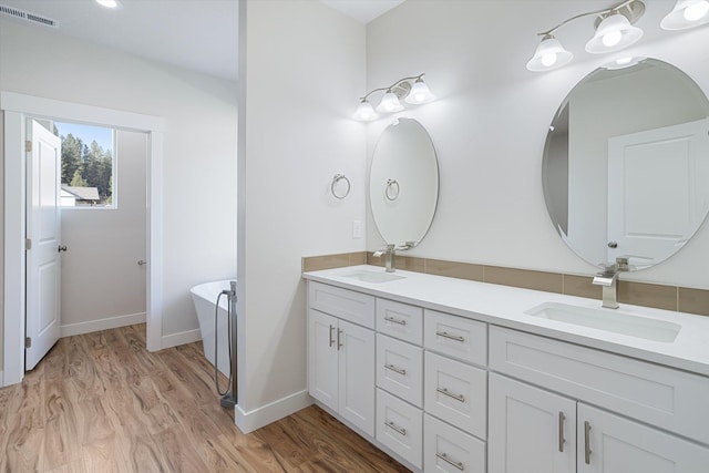 3405 E Yearling Rd, Chattaroy, WA 99003 - full bathroom featuring double vanity, a freestanding tub, wood finished floors, and baseboards