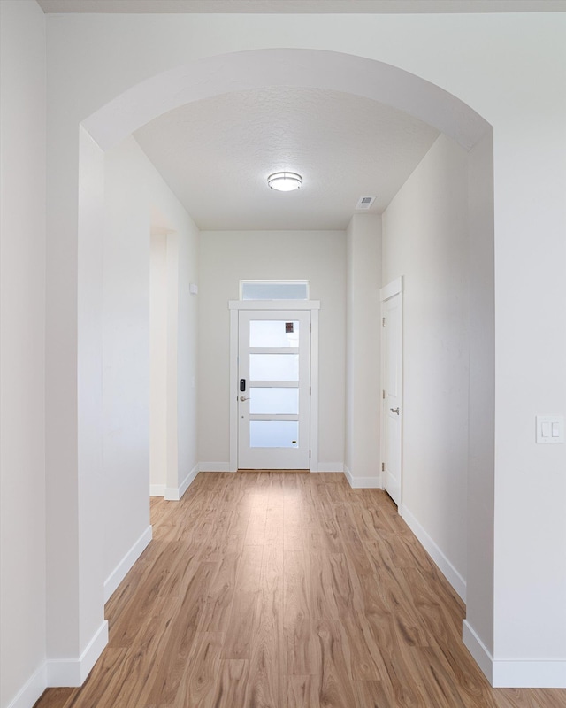 3405 E Yearling Rd, Chattaroy, WA 99003 - hallway with arched walkways, light wood finished floors, and baseboards