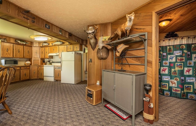 1651 Riverbend Loop Rd, Cusick, WA 99119 - kitchen with white appliances, dark colored carpet, under cabinet range hood, brown cabinetry, and wood walls