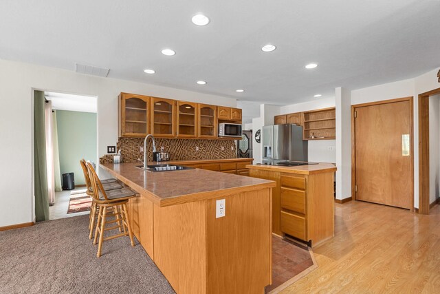 2378 Eagle River Way, Kettle Falls, WA 99141 - kitchen with open shelves, stainless steel fridge with ice dispenser, brown cabinets, a peninsula, and glass insert cabinets