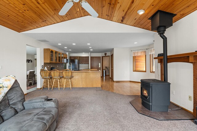2378 Eagle River Way, Kettle Falls, WA 99141 - carpeted living room featuring a wood stove, recessed lighting, lofted ceiling, a ceiling fan, and baseboards