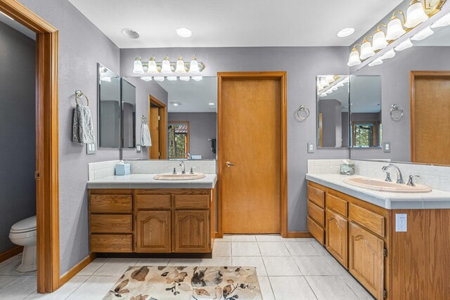 2378 Eagle River Way, Kettle Falls, WA 99141 - full bathroom with two vanities, toilet, tile patterned flooring, and baseboards