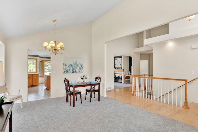 4605 E Birkdale Ln, Spokane, WA 99223 - dining area featuring a chandelier, light carpet, and high vaulted ceiling