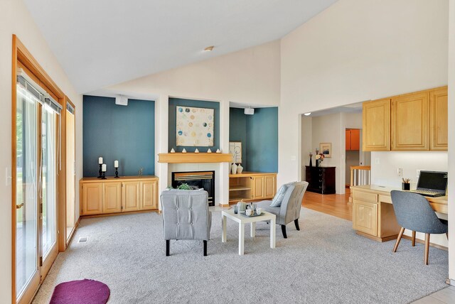 4605 E Birkdale Ln, Spokane, WA 99223 - living area with healthy amount of natural light, light colored carpet, a glass covered fireplace, a desk, and high vaulted ceiling