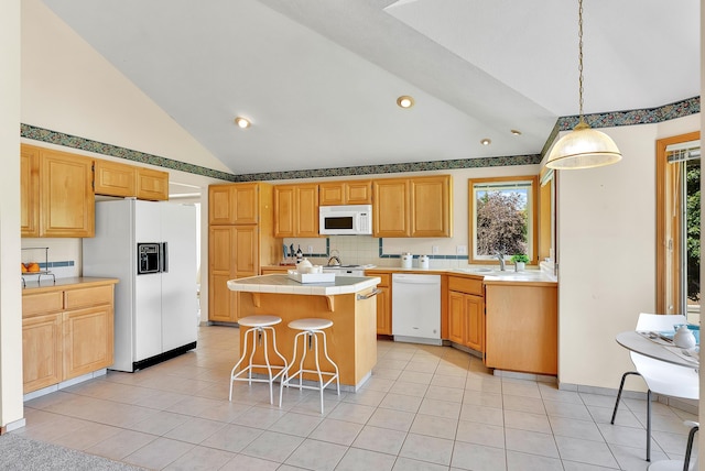 4605 E Birkdale Ln, Spokane, WA 99223 - kitchen featuring white appliances, tile counters, a kitchen island, a breakfast bar area, and light tile patterned floors