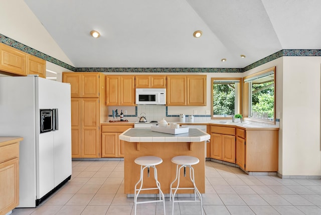 4605 E Birkdale Ln, Spokane, WA 99223 - kitchen featuring white appliances, lofted ceiling, tile countertops, a kitchen island, and light brown cabinetry